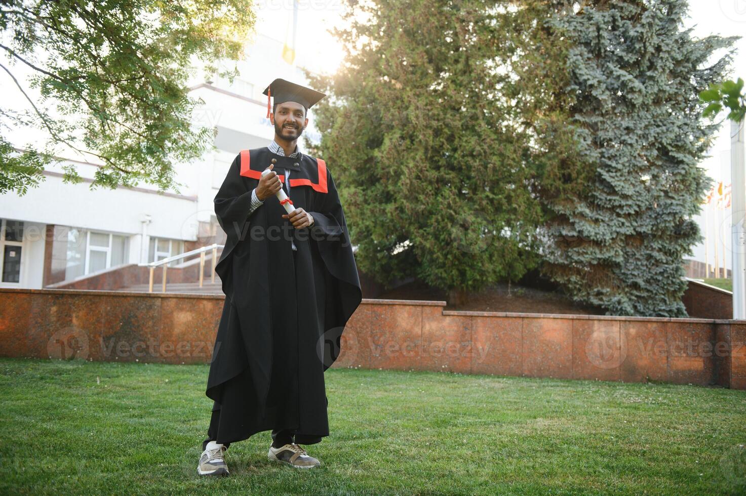 portrait of successful indian student in graduation gown. photo