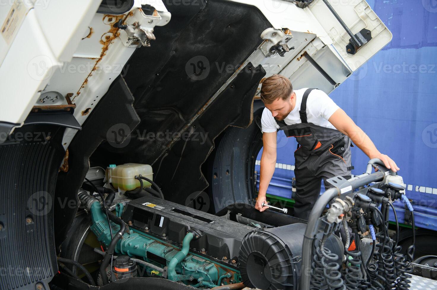 Professional truck mechanic working in vehicle repair service. photo