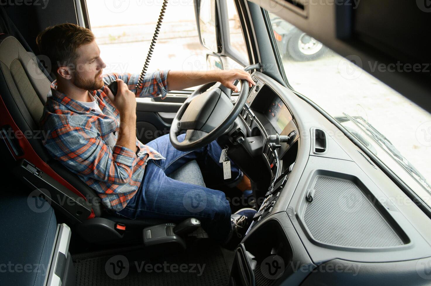 Male truck driver talking by CB radio system in his vehicle photo