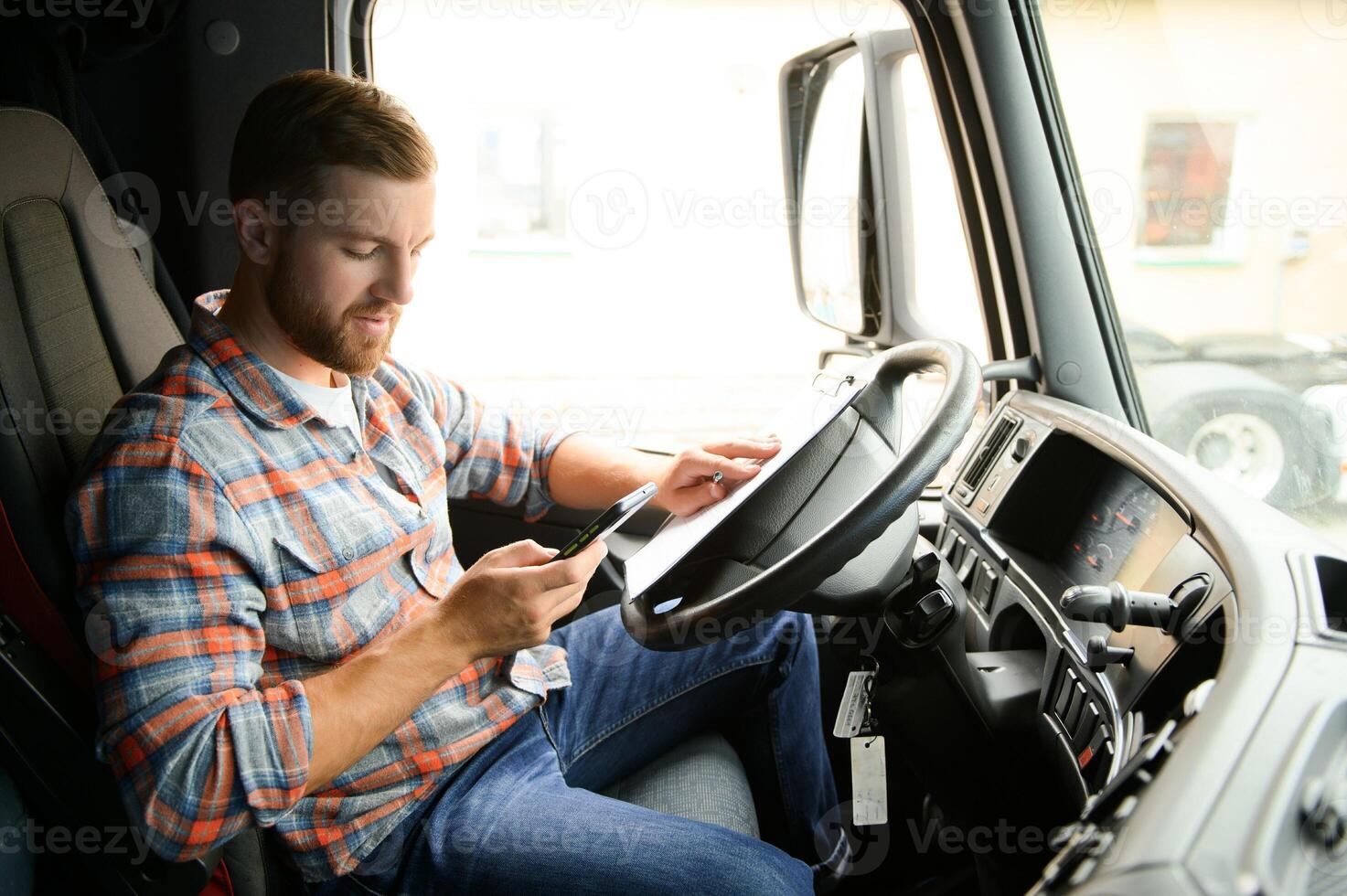 forwarder driver sits behind the wheel of a car and examines waybills documentation for the cargo. photo