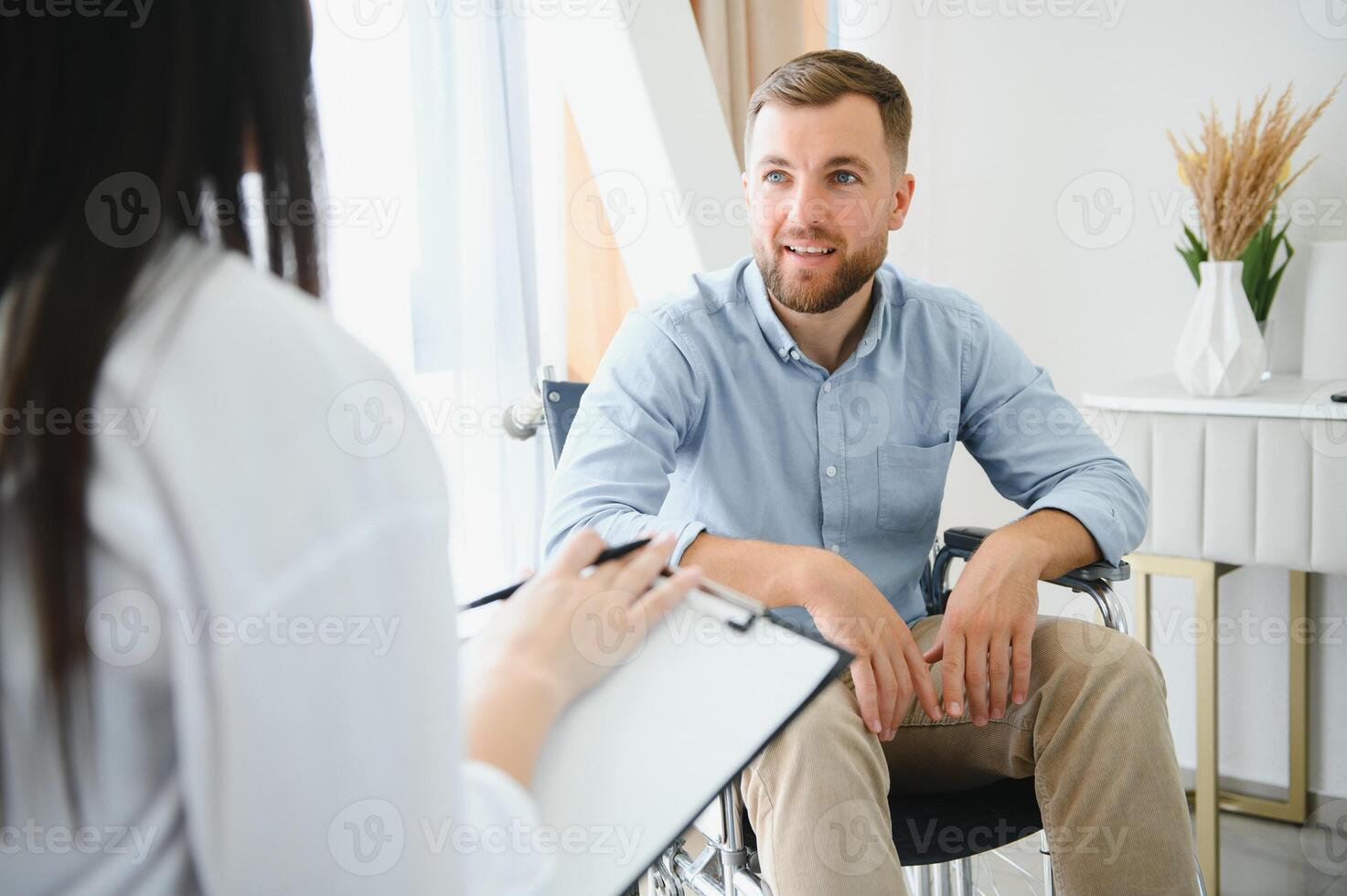 Portrait of female psychiatrist interviewing handicapped man during therapy session, copy space. photo
