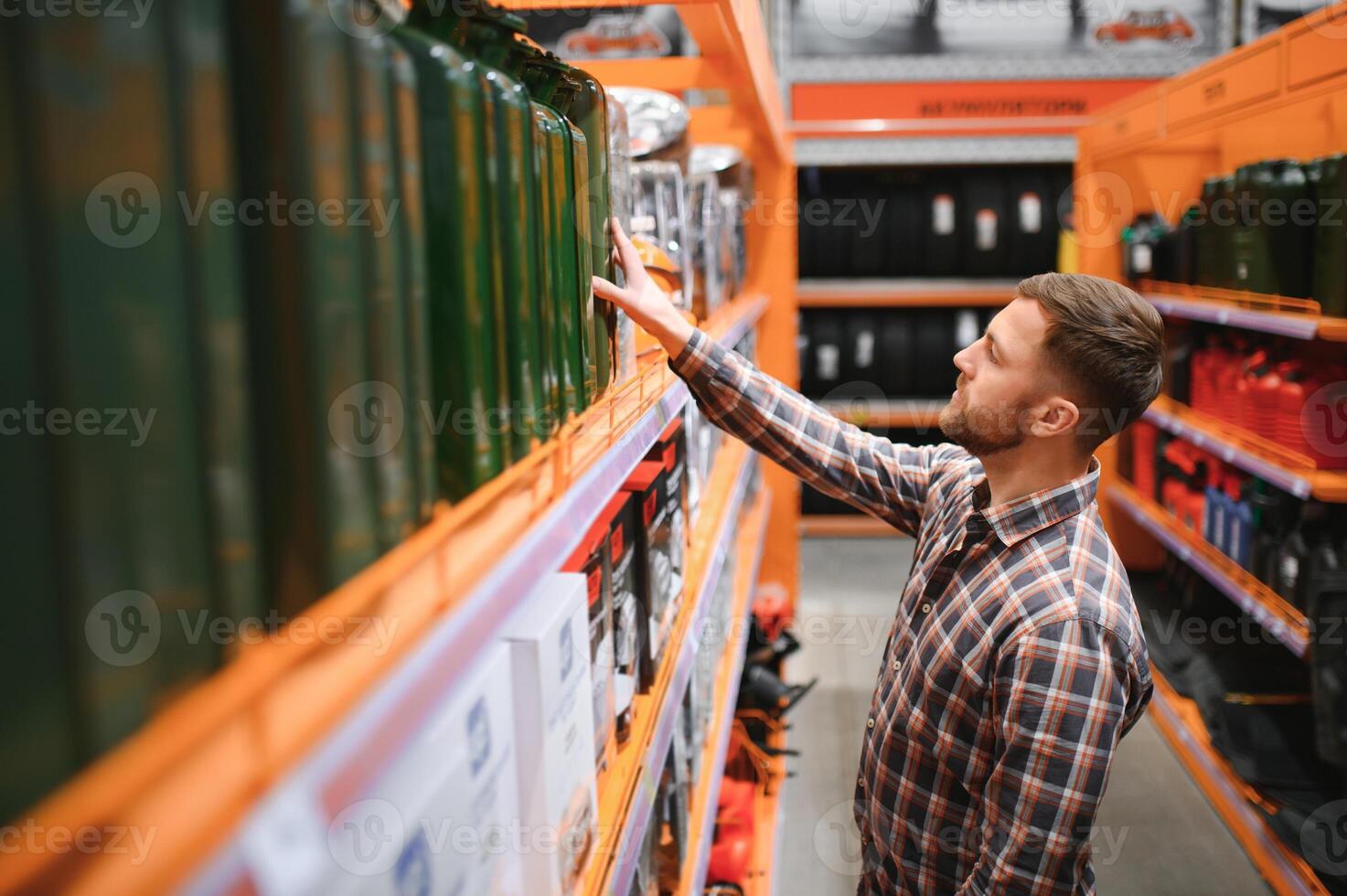 A male customer stands in an auto parts store with a jerry can photo