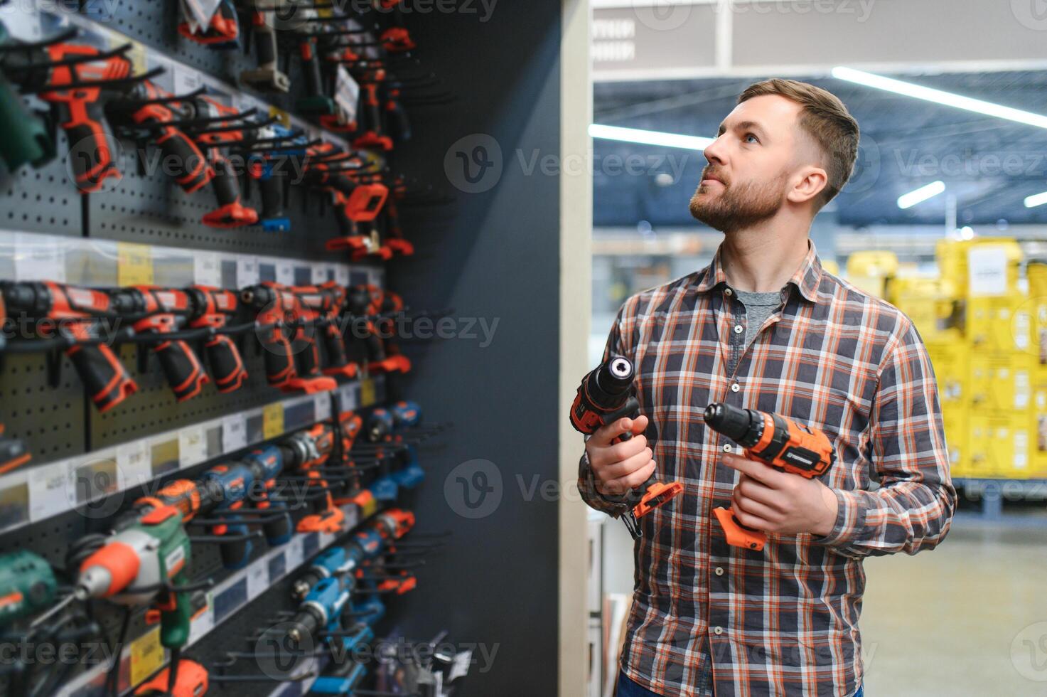 handsome young man shopping for tools at hardware store photo