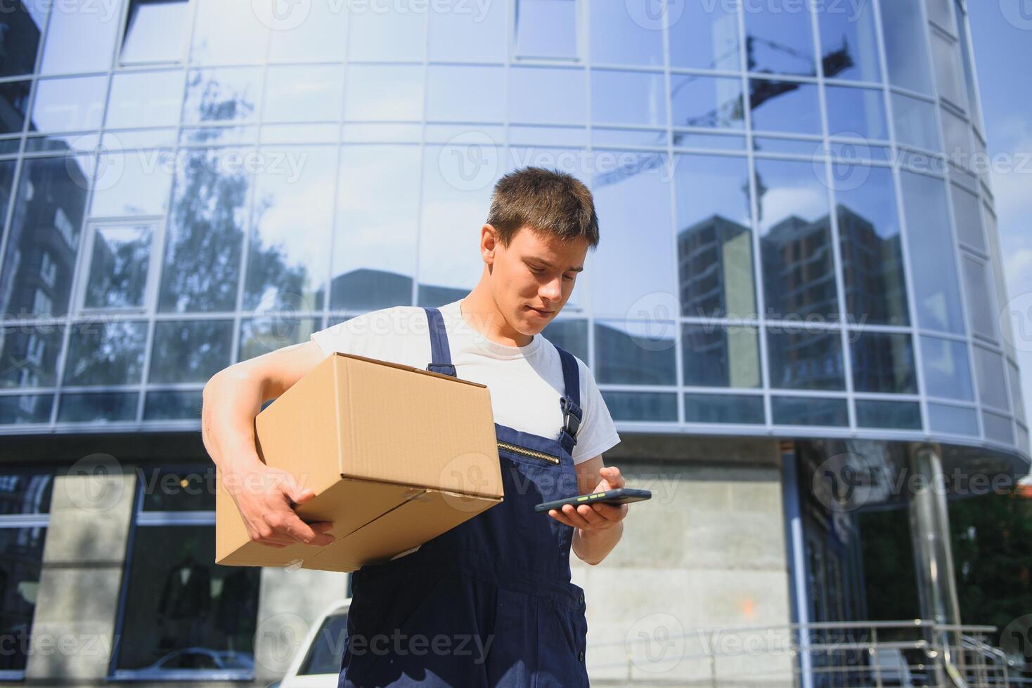 Smiling delivery man standing in front of his car photo
