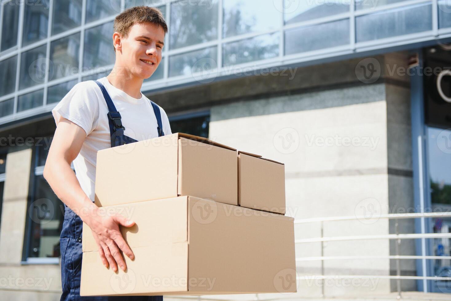 Smiling delivery man holding a paper box photo