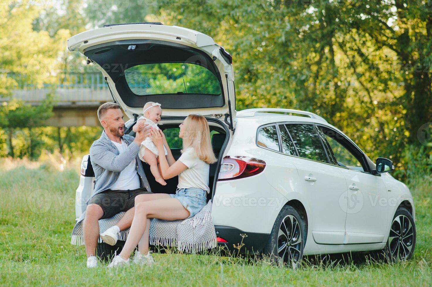 Happy family near car trunk on sunny day. Road trip photo