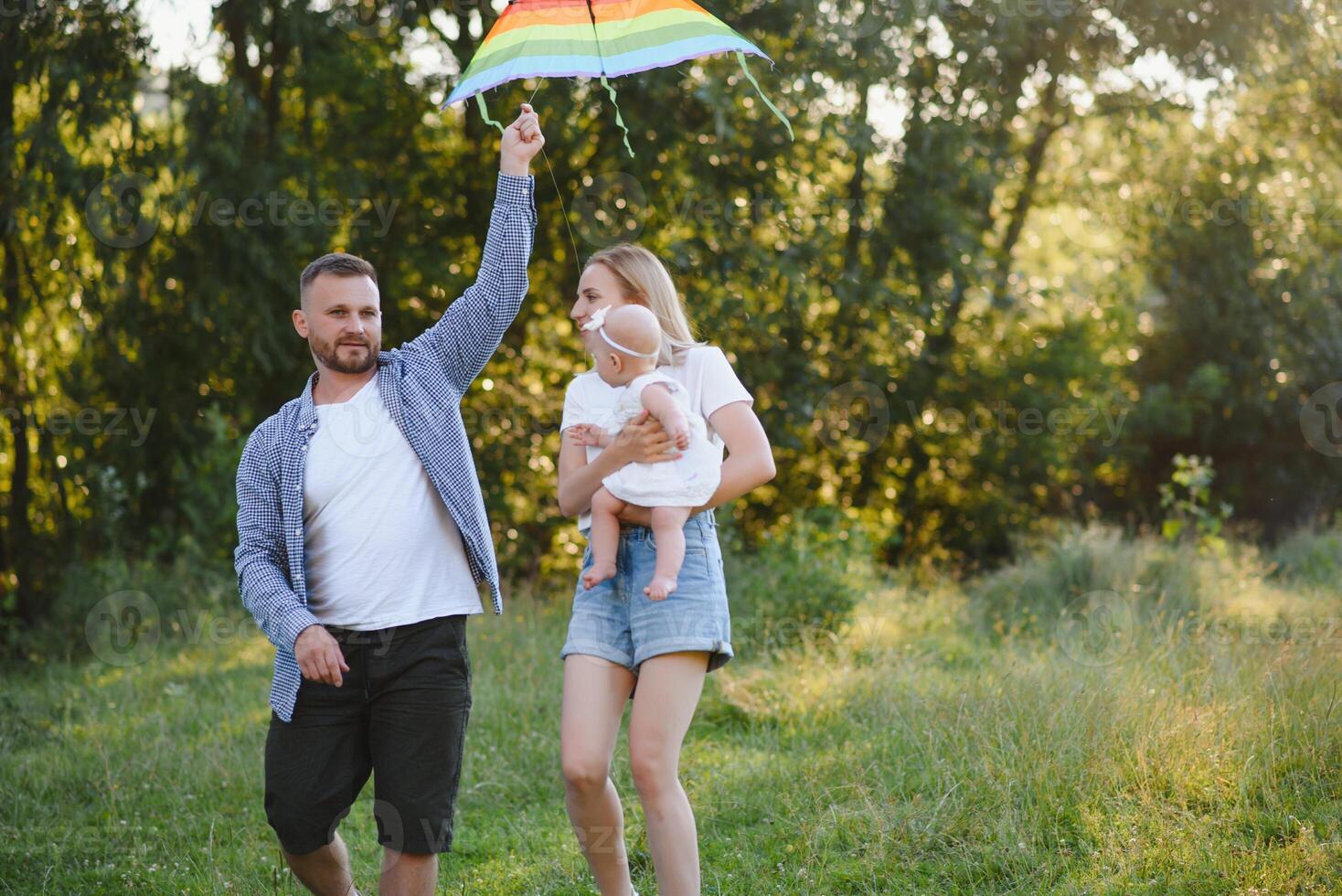 Happy family walking on field in nature at sunset photo