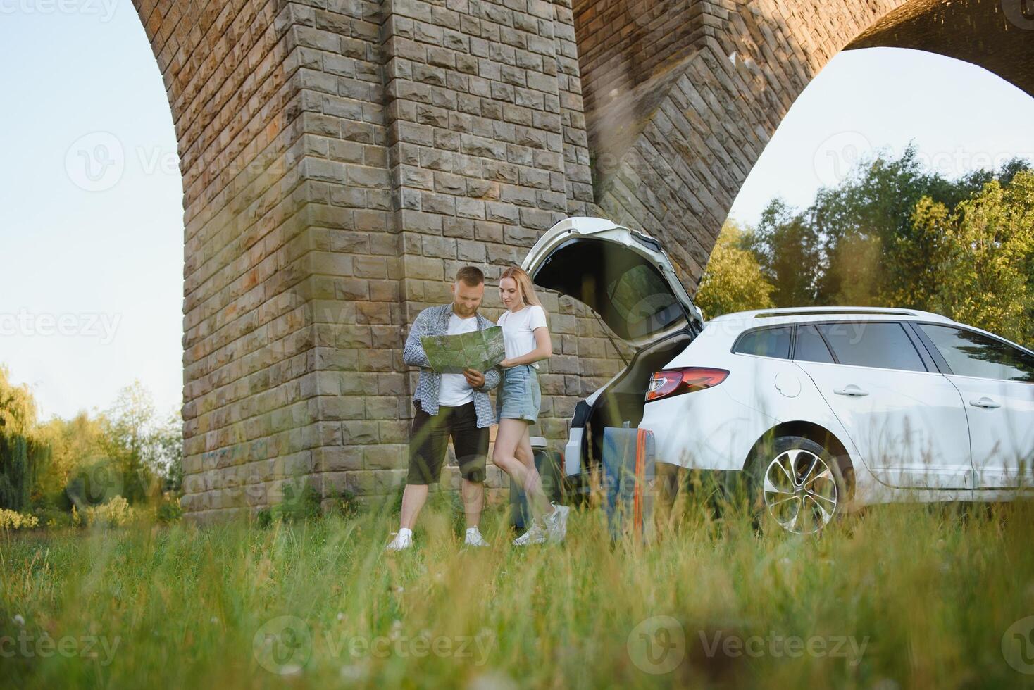 Vacation, Travel - family ready for the travel for summer vacation. suitcases and car route. People with map in hands planning road trip. travel concept. traveler. photo