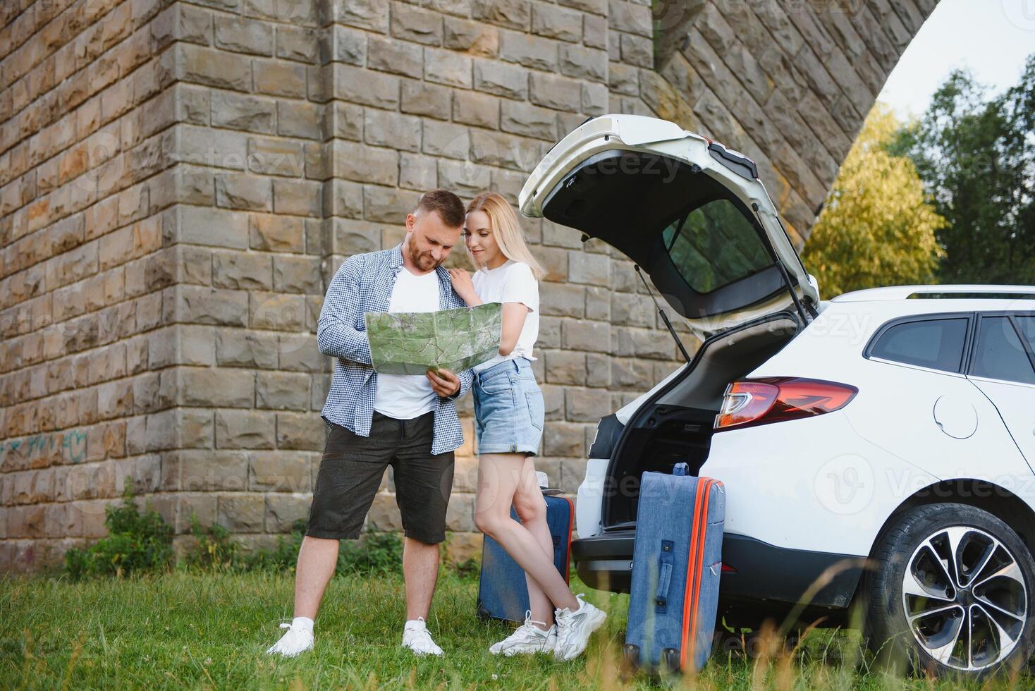 Vacation, Travel - family ready for the travel for summer vacation. suitcases and car route. People with map in hands planning road trip. travel concept. traveler. photo