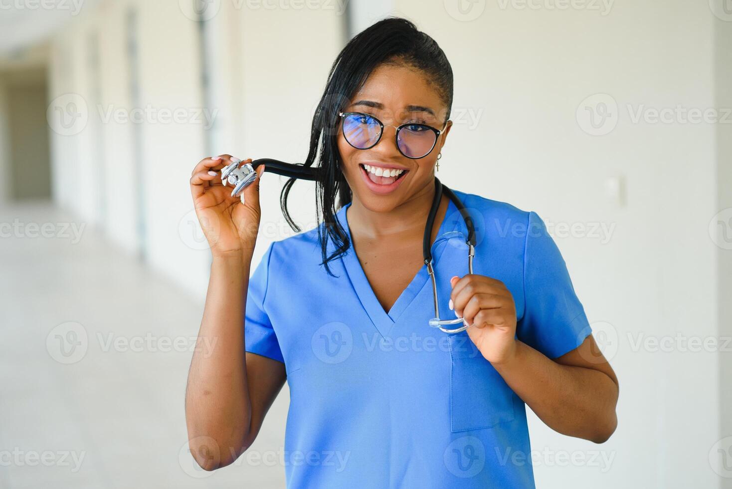 Portrait confident African American female doctor medical professional writing patient notes isolated on hospital clinic hallway windows background. Positive face expression photo