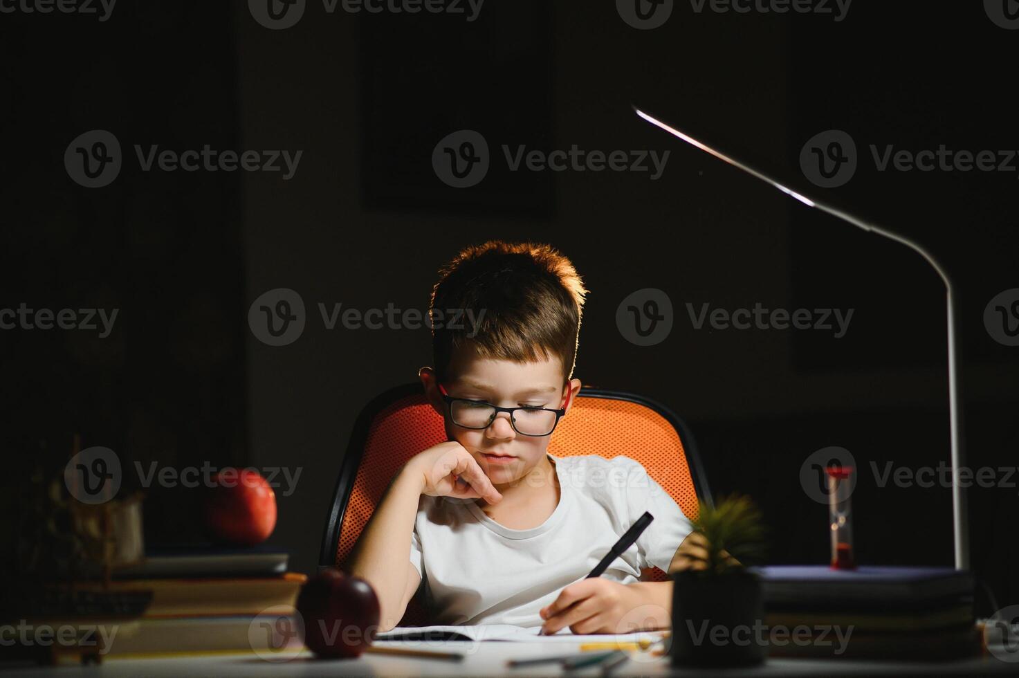 boy doing homework at home in evening photo