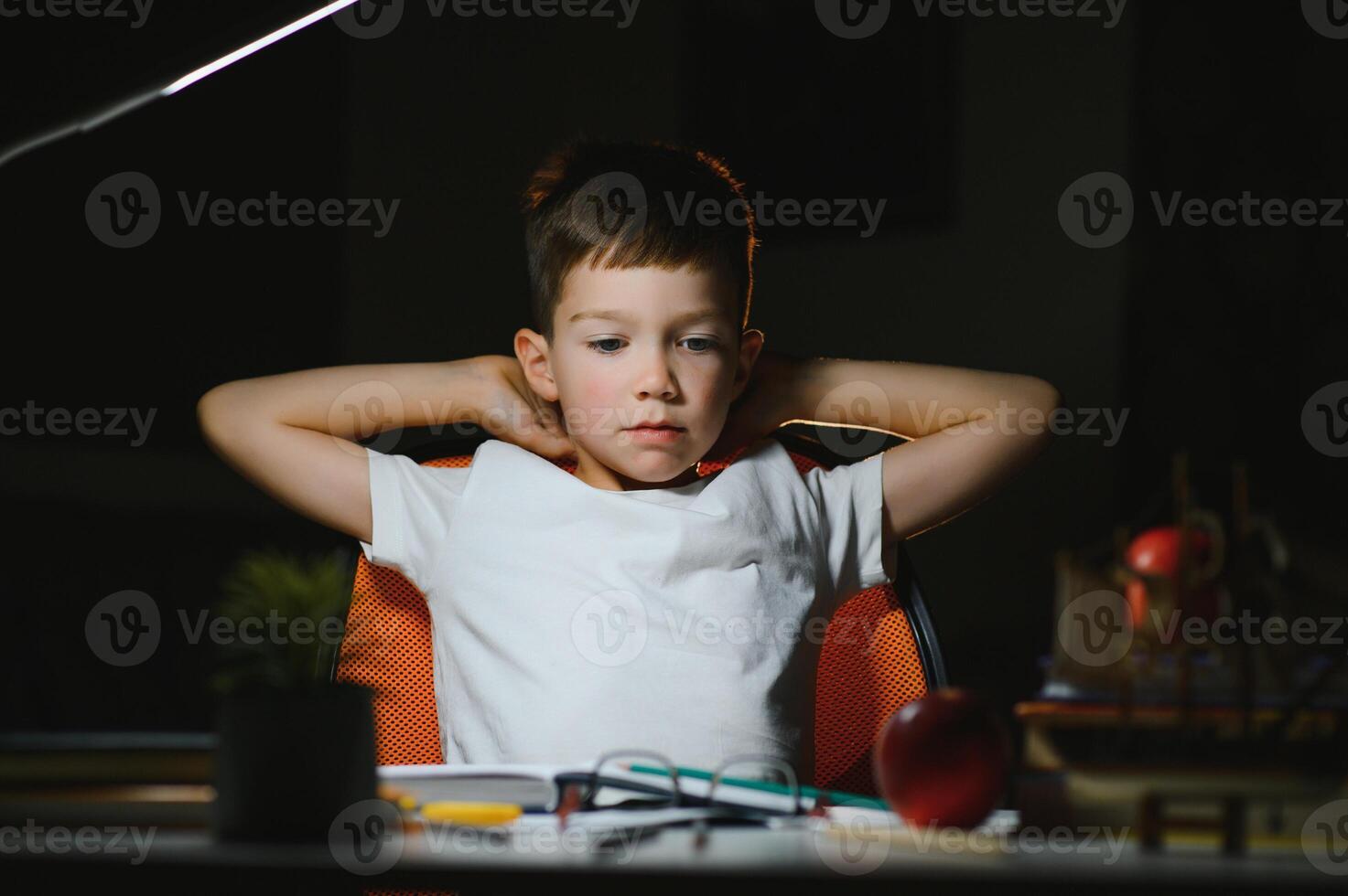 schoolboy doing homework at the table in his room. photo