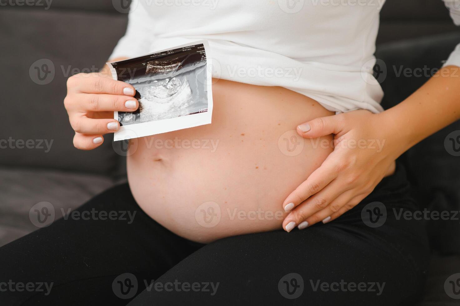 Pregnant women holding echo pictures in hand photo
