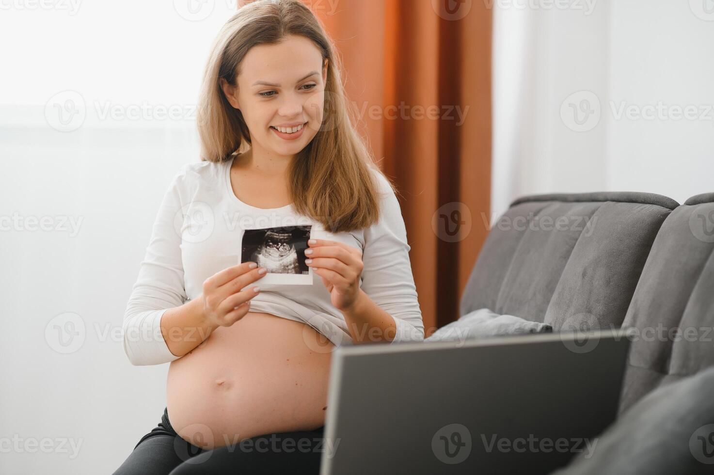 selective focus of happy pregnant woman showing ultrasound photos while having call