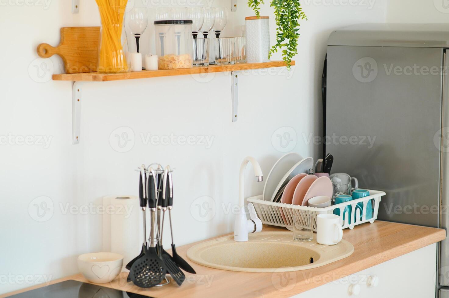 Kitchen brass utensils, chef accessories. Hanging copper kitchen with white tiles wall photo
