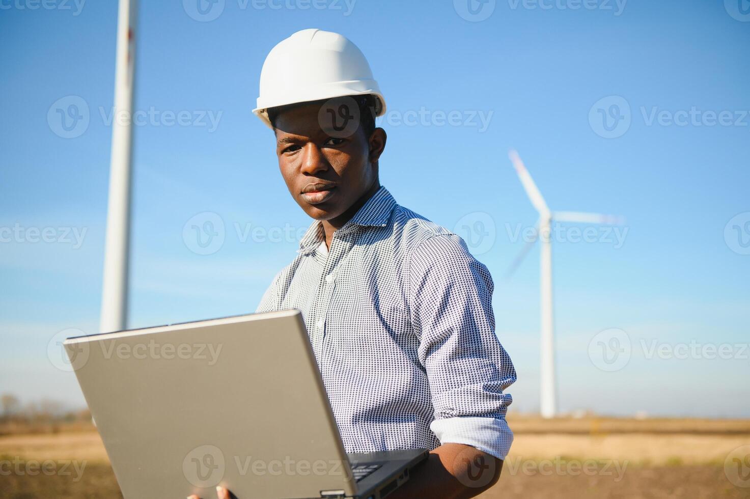 Engineer African man standing with wind turbine photo