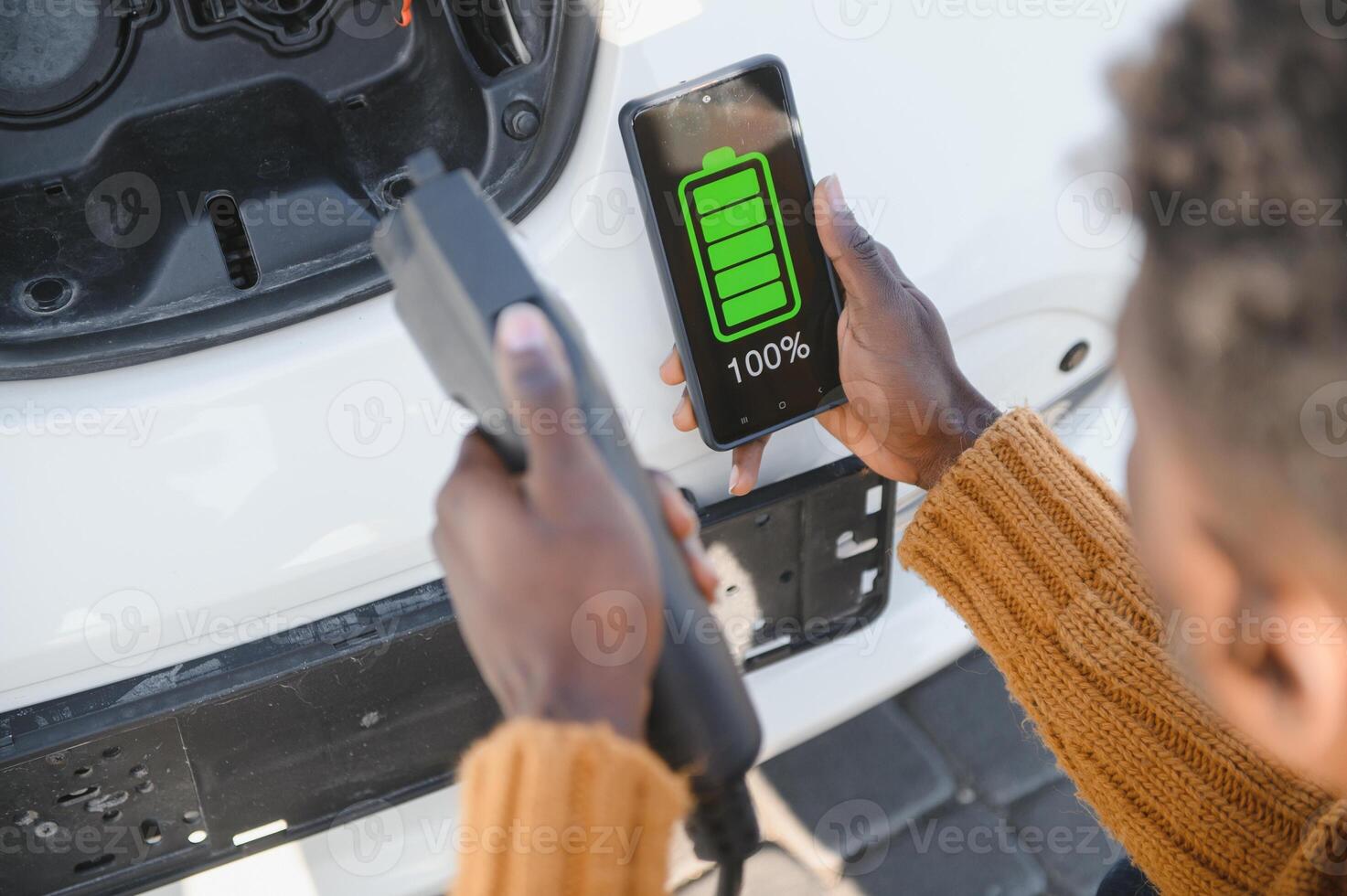 Smartphone app shows charging status of the electric car battery. Electro transport concept photo