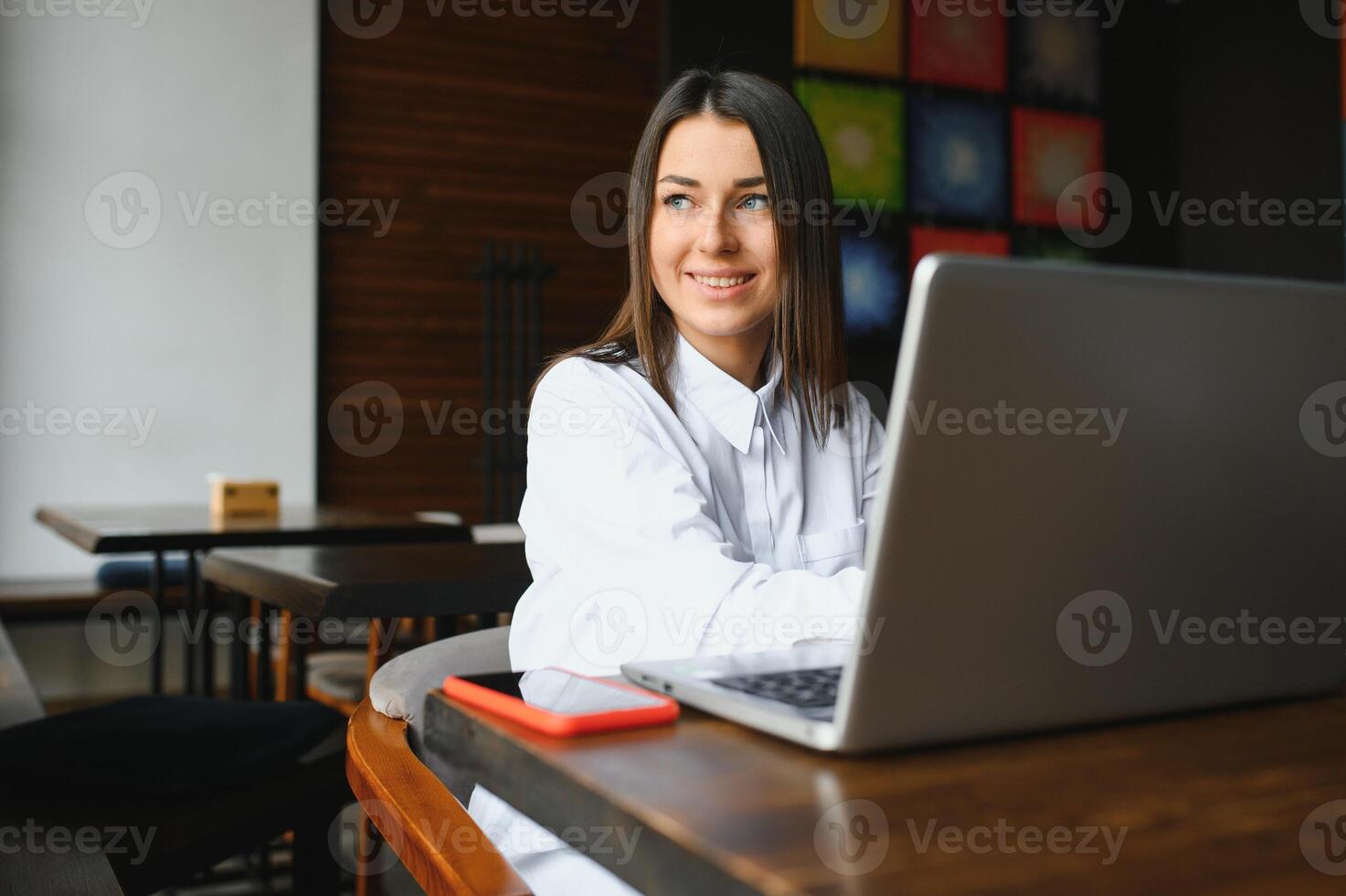 Beautiful Caucasian woman dreaming about something while sitting with portable net-book in modern cafe bar, young charming female freelancer thinking about new ideas during work on laptop computer photo