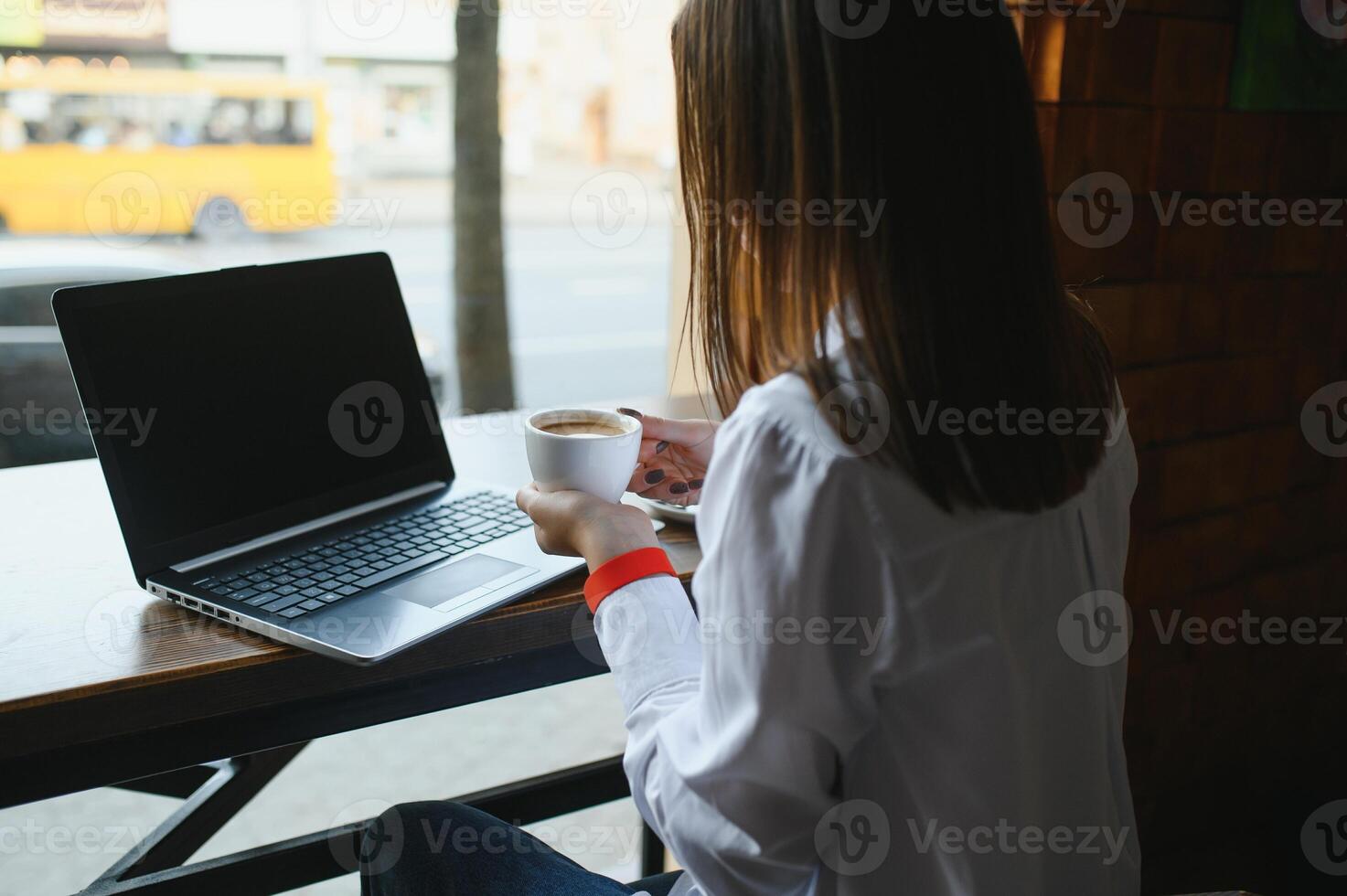 Beautiful Caucasian woman dreaming about something while sitting with portable net-book in modern cafe bar, young charming female freelancer thinking about new ideas during work on laptop computer photo