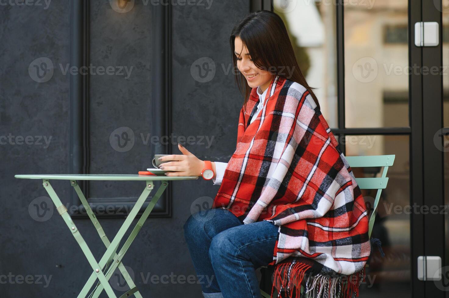 Portrait of young beautiful woman sitting in a cafe outdoor drinking coffee photo