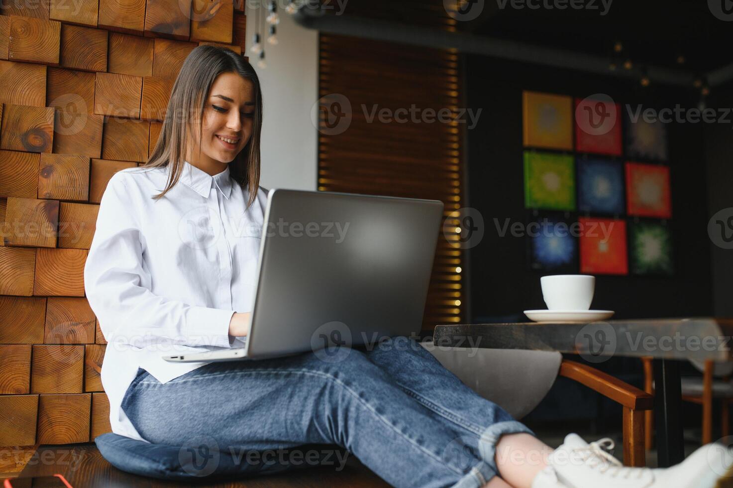 Beautiful Caucasian woman dreaming about something while sitting with portable net-book in modern cafe bar, young charming female freelancer thinking about new ideas during work on laptop computer photo