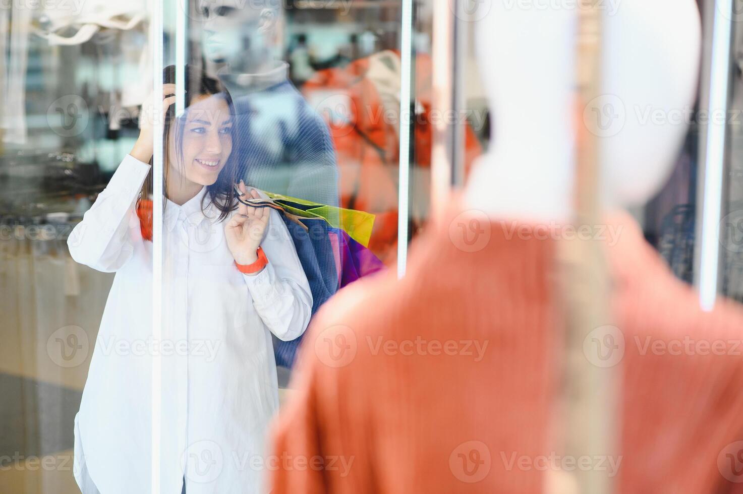 Young girl is choosing to buy clothes at the mall photo