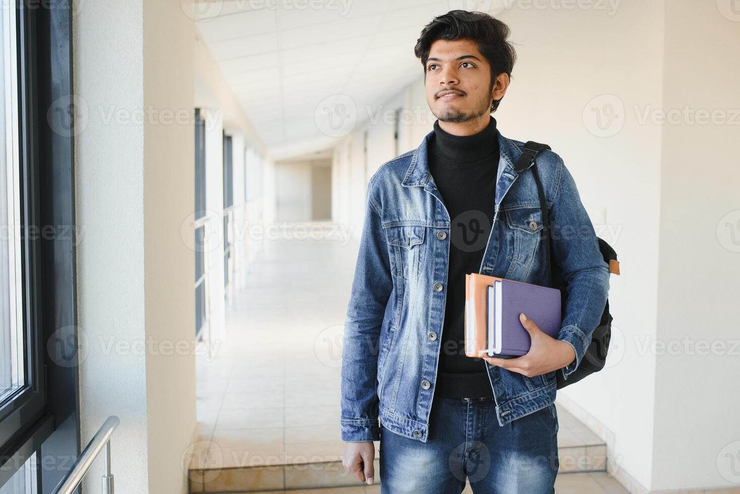 Portrait of indian college boy holding books. photo