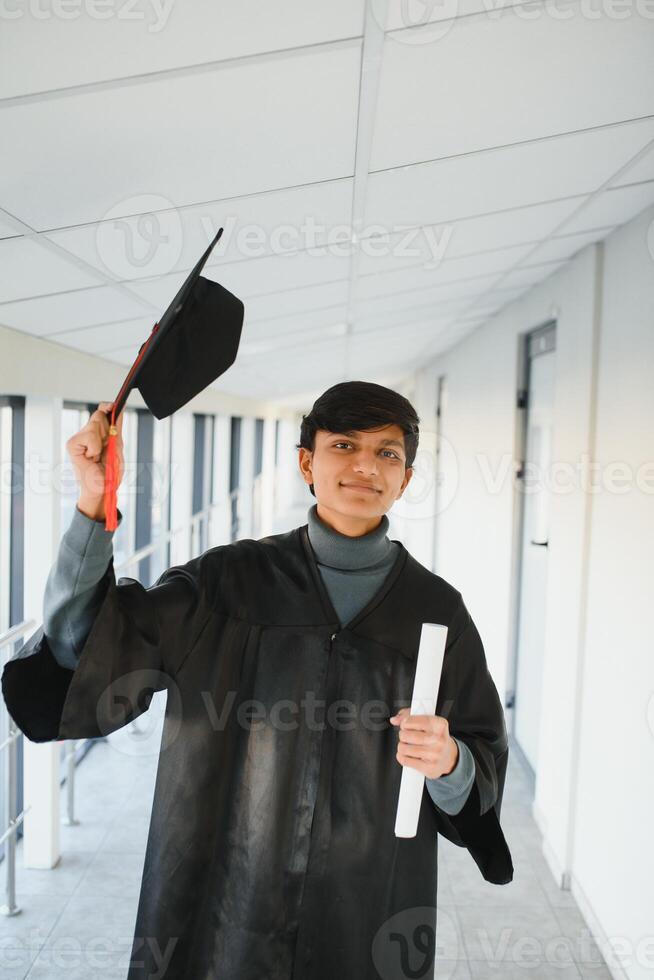 Emotional indian graduate in graduation glow and diploma. photo