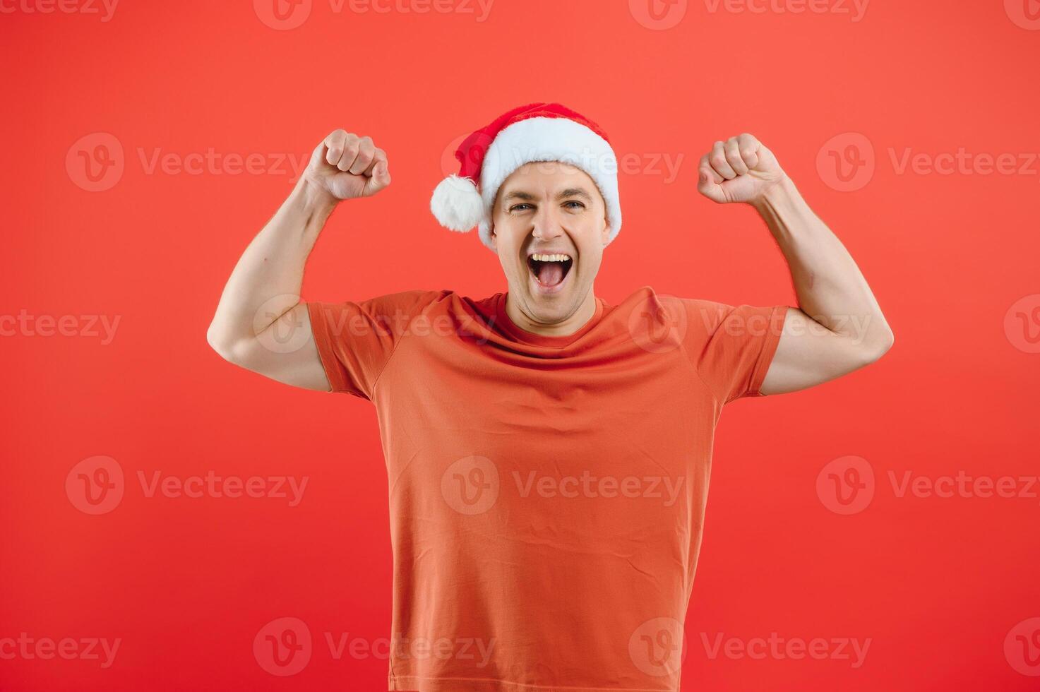concept people, body language, approval, recommendationan excited man Santa Claus hat isolated on red studio background with space for text photo
