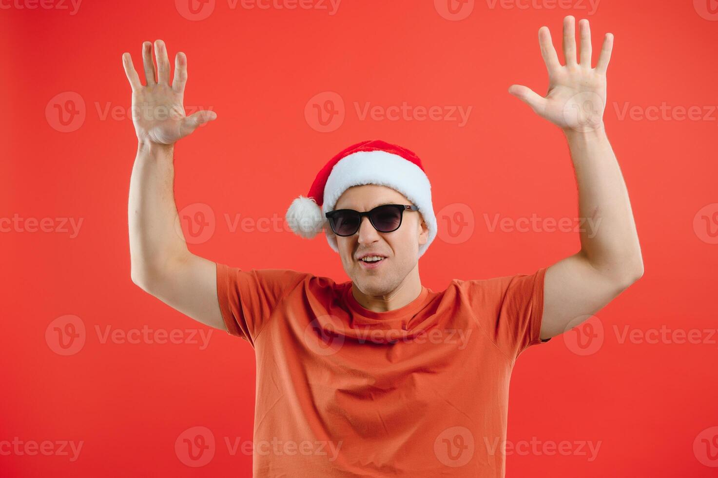 concept people, body language, approval, recommendationan excited man Santa Claus hat isolated on red studio background with space for text photo