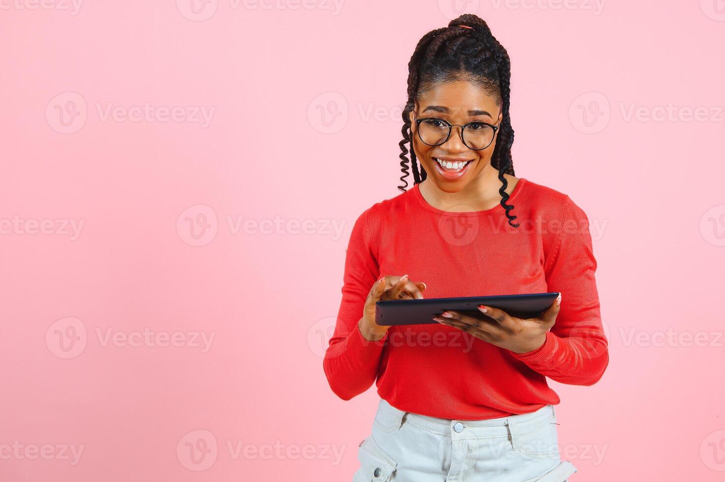 Cool gadget. Interested girl using digital tablet on pink background. photo