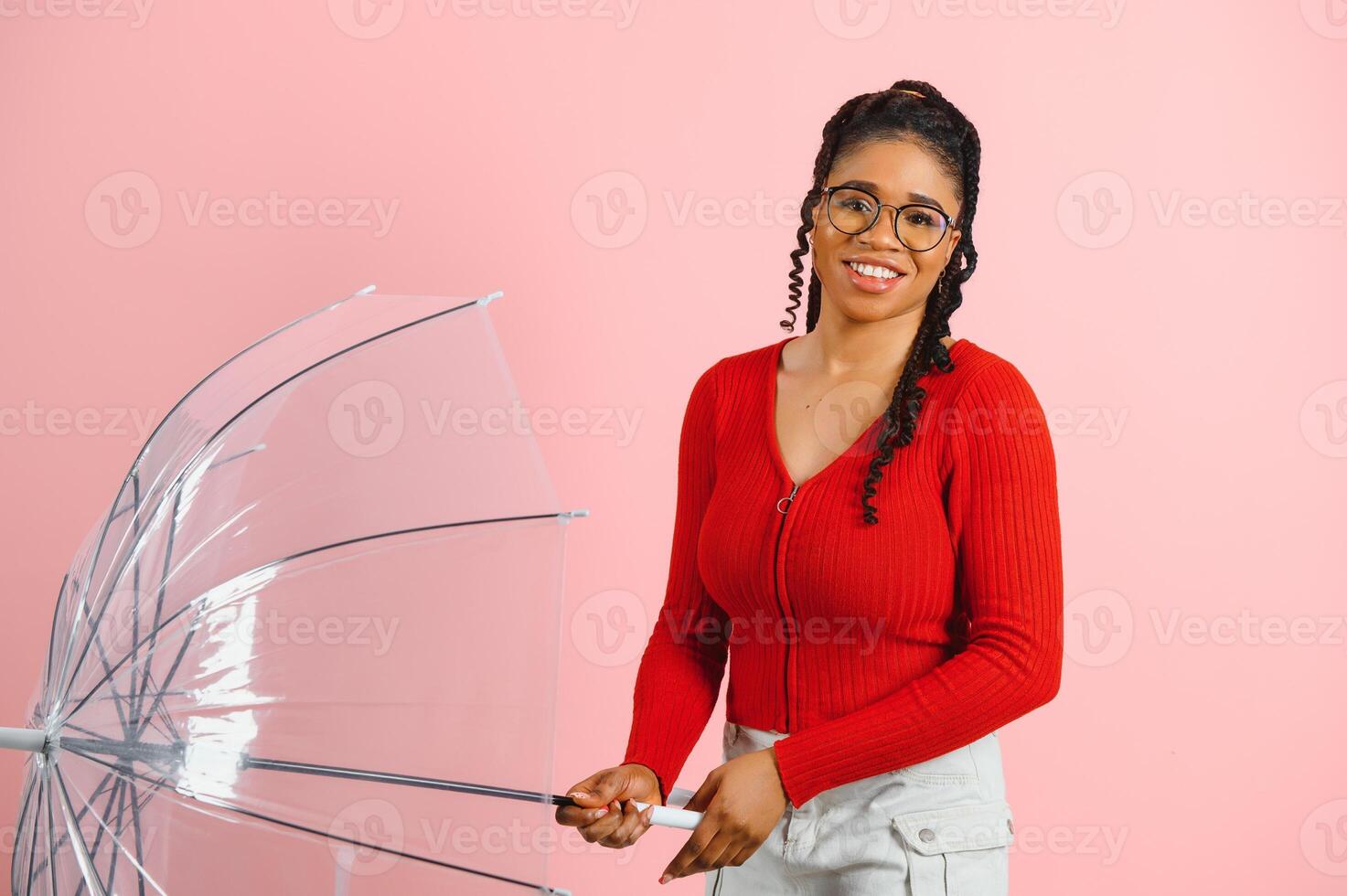 Portrait of young beautiful african american woman holding umbrella isolated on a Pink background. photo