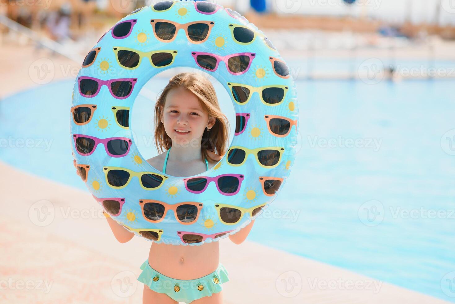 The concept of recreation at sea. The girl holds an inflatable circle for swimming by the pool photo