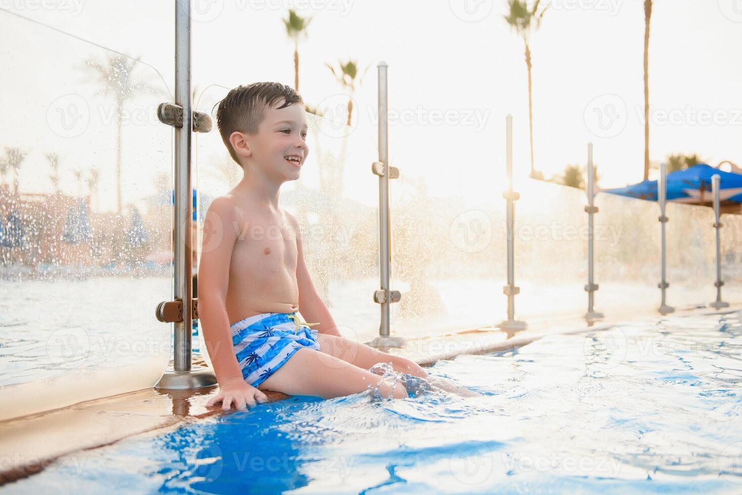 Little cute boy in blue water of the swimming pool, summer time for fun photo