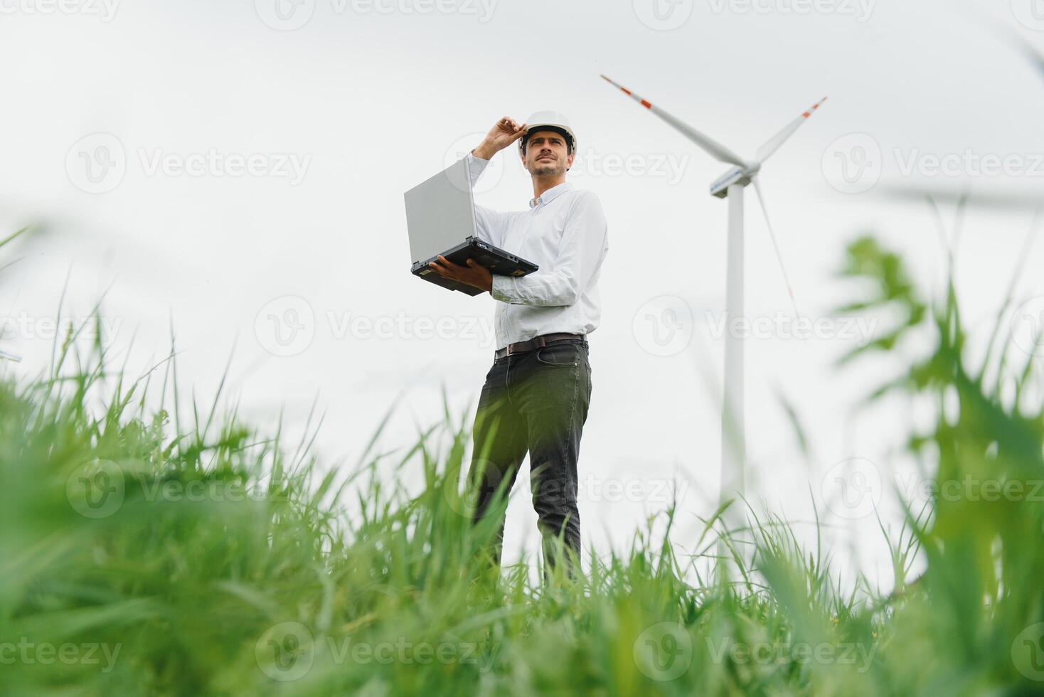 Engineer worker with laptop or computer at wind turbine power station construction site,copy space. photo
