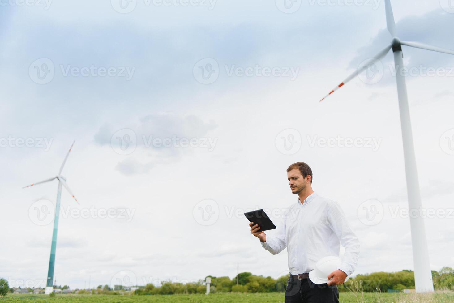 Wind turbines generating electricity. energy conservation concept and worker staff engineer hold tablet photo