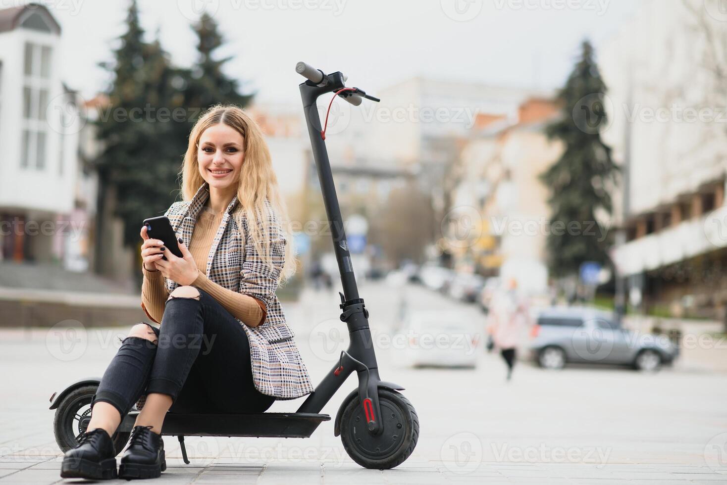 young woman on electro scooter in city. woman riding scooter in sunset light in street photo