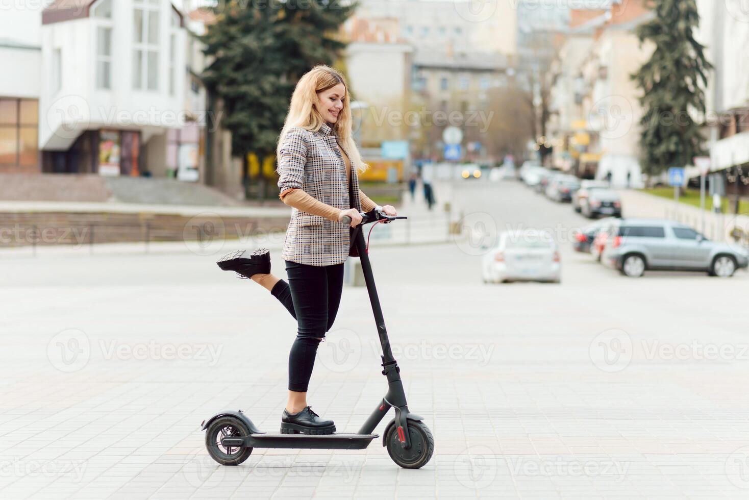 Girl in electric scooter riding in the old city center photo