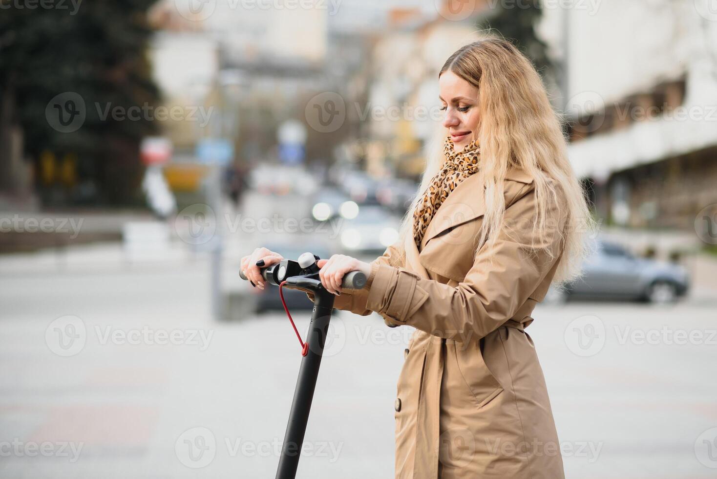young woman on electro scooter in city. woman riding scooter in sunset light in street photo