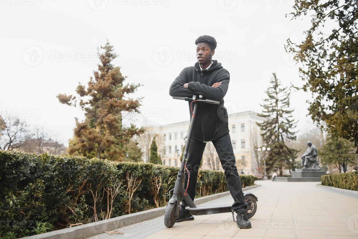 Full body side portrait happy african American man on mobile scooter on street photo