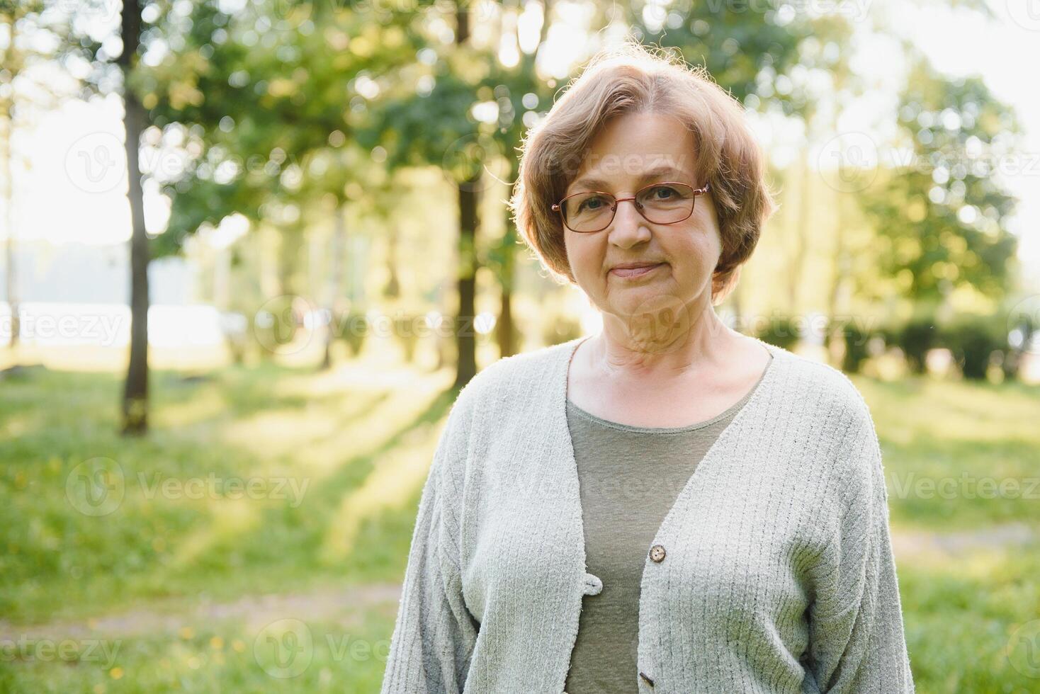 Portrait of a happy Senior woman in summer park photo