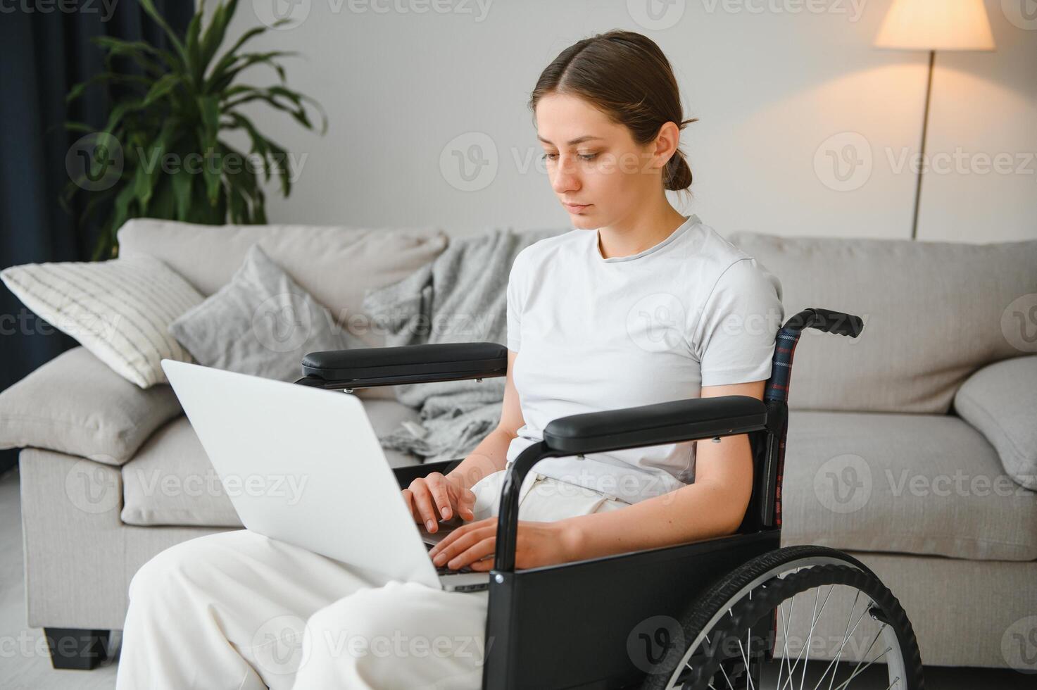 hembra Lanza libre programador sentado en silla de ruedas y utilizando ordenadores mientras codificación web juego a hogar. foto