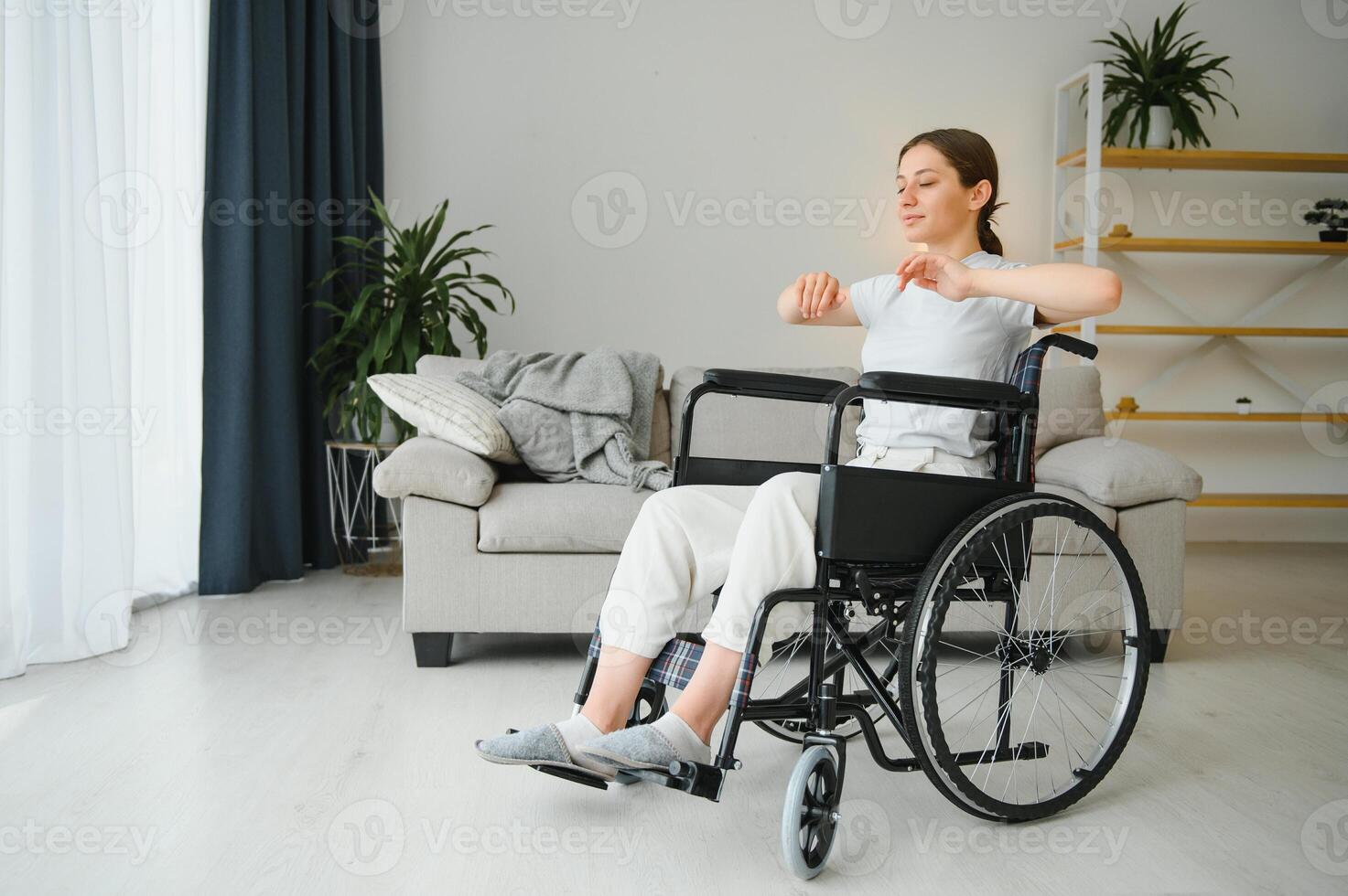 Woman in wheelchair working out in living room photo