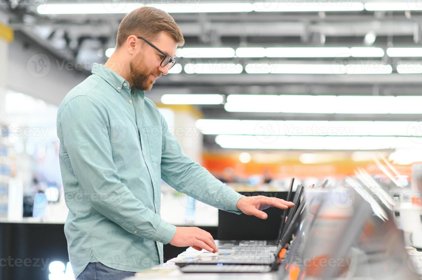 Man buying laptop at electronic store photo