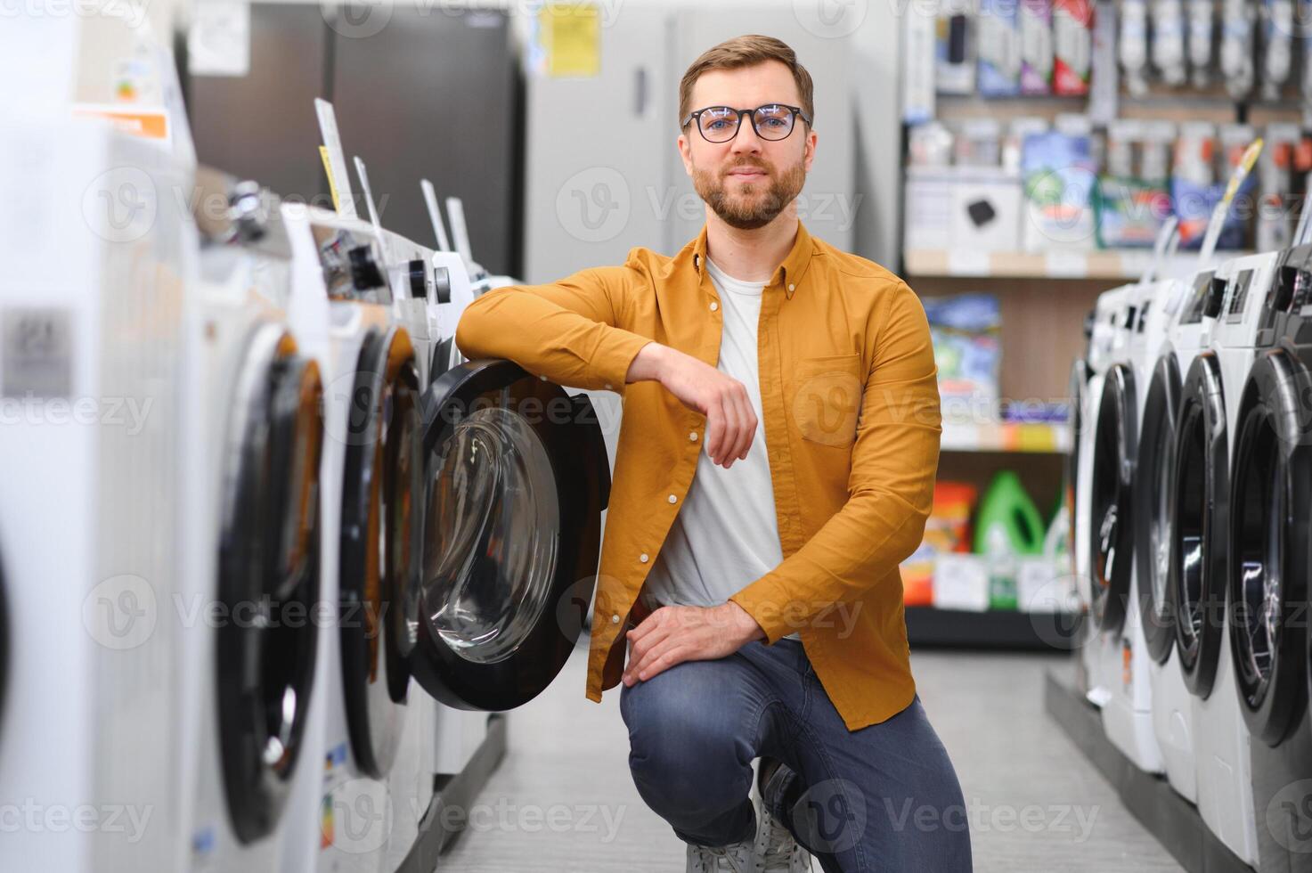 man choosing washing machine in showroom photo