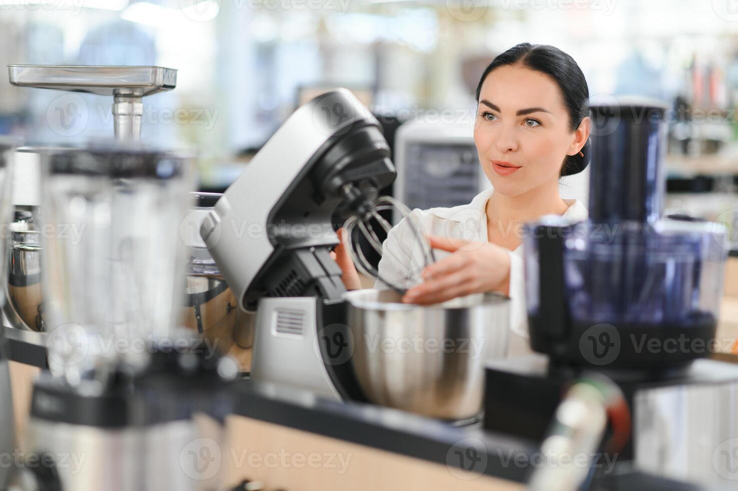 Woman choosing kitchen equipments at store photo