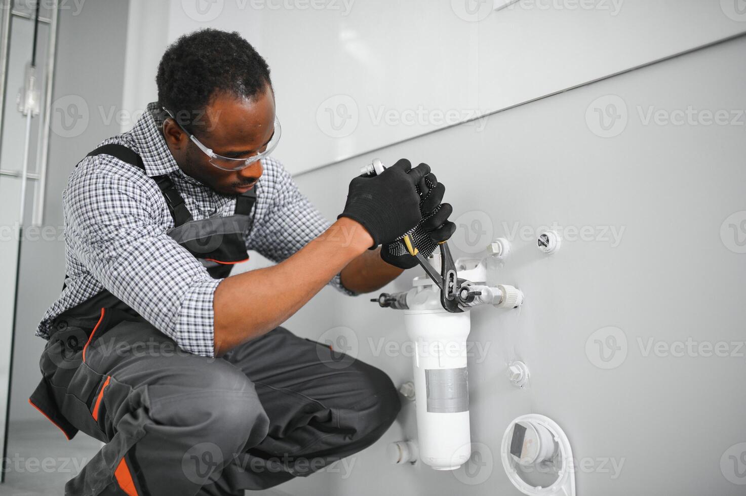 African american plumber change the water filter. photo
