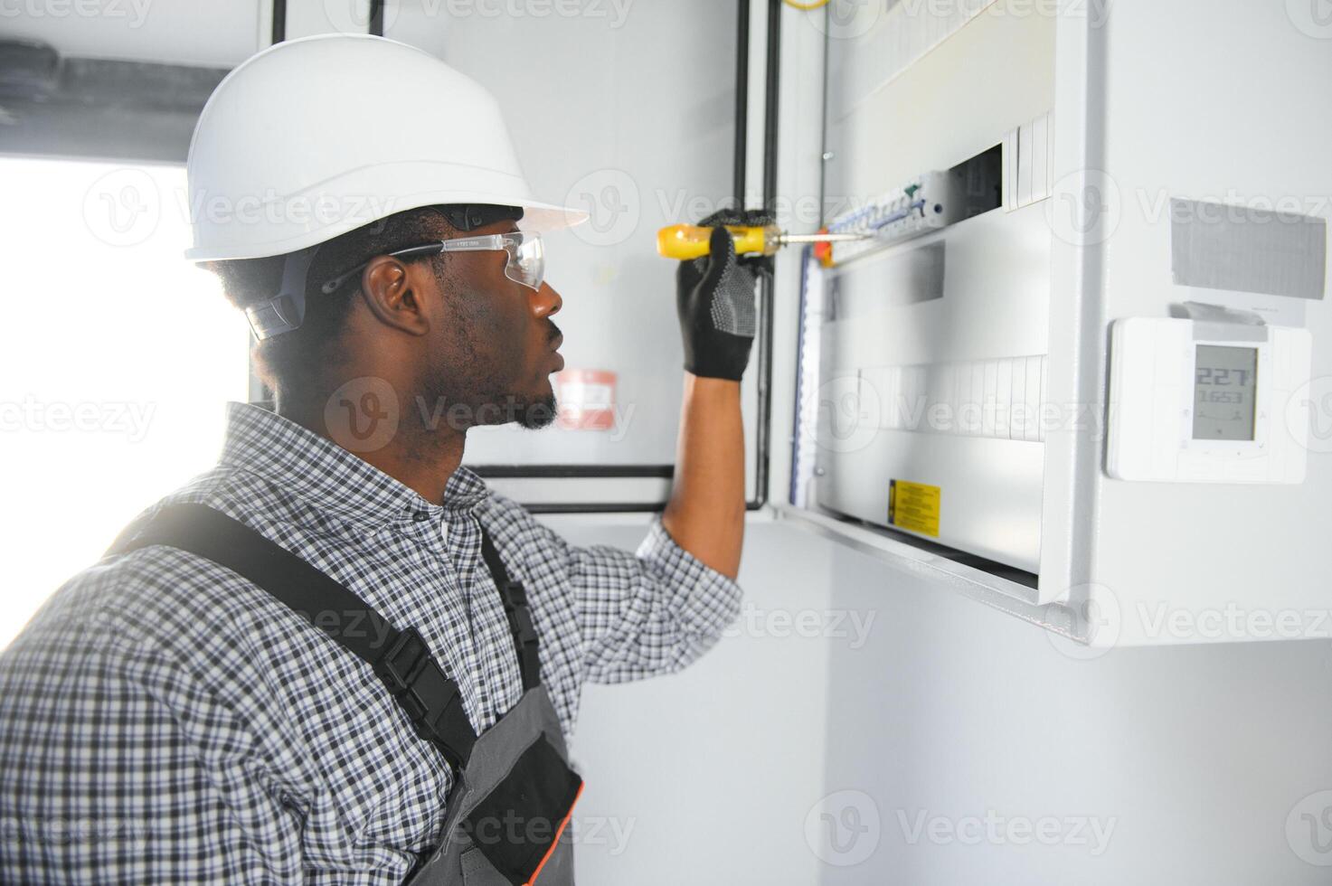 A male electrician works in a switchboard photo