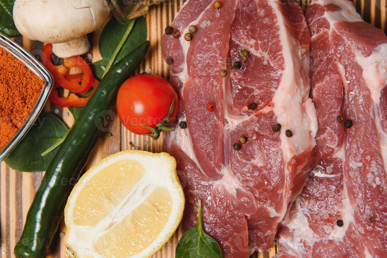raw meat with fresh vegetables and spices on wooden background. Top view. Free space for text. prepare yourself concept. photo