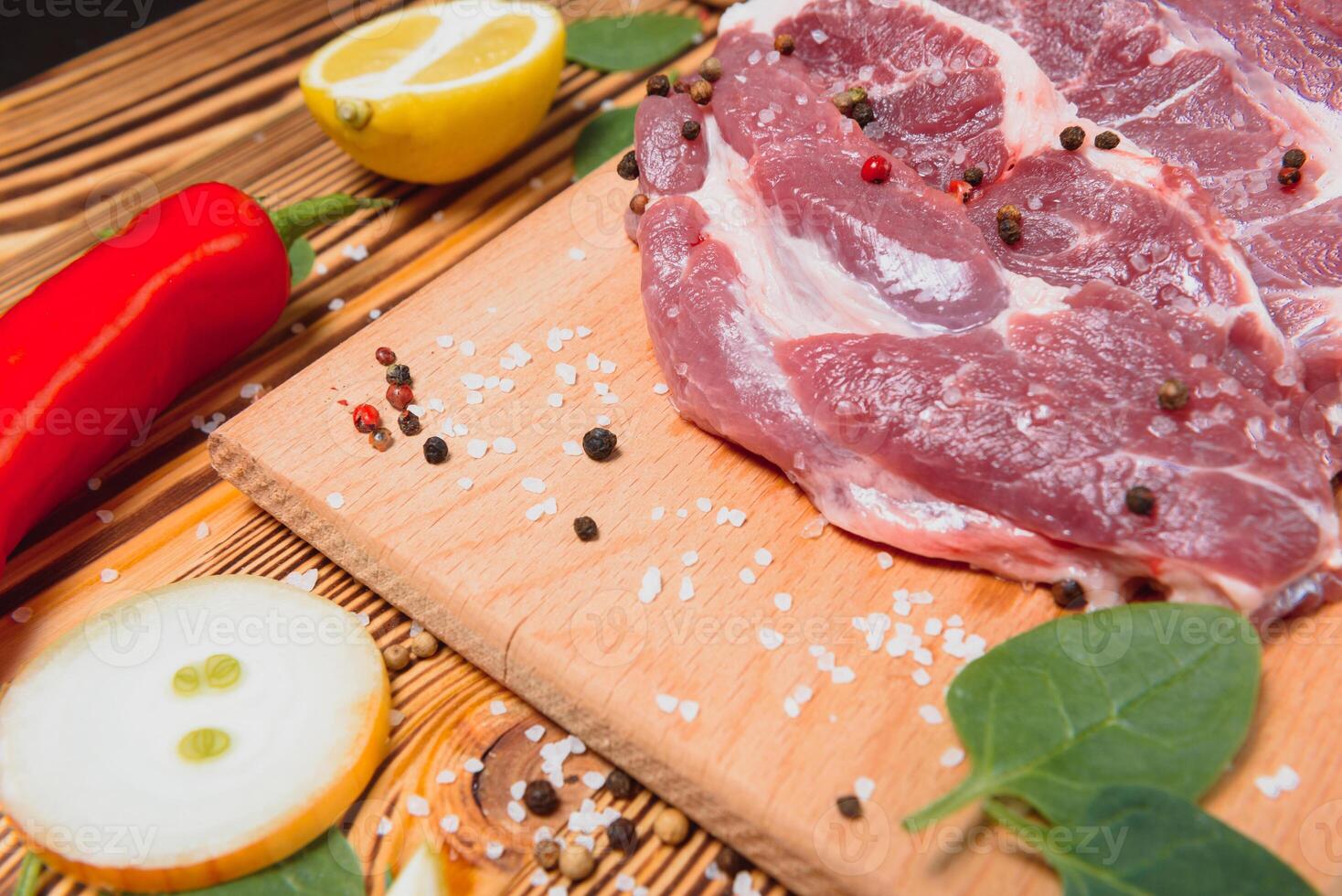 Raw pork chop steak prepare in kitchen with vegetable and spices for food and cooking concept photo